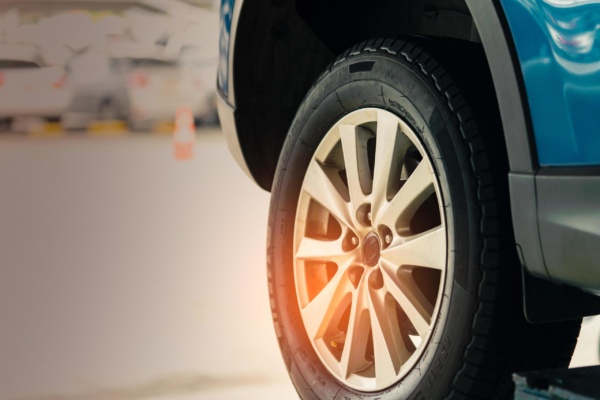 selective-focus-on-blue-suv-car-rear-wheel-on-blurred-background